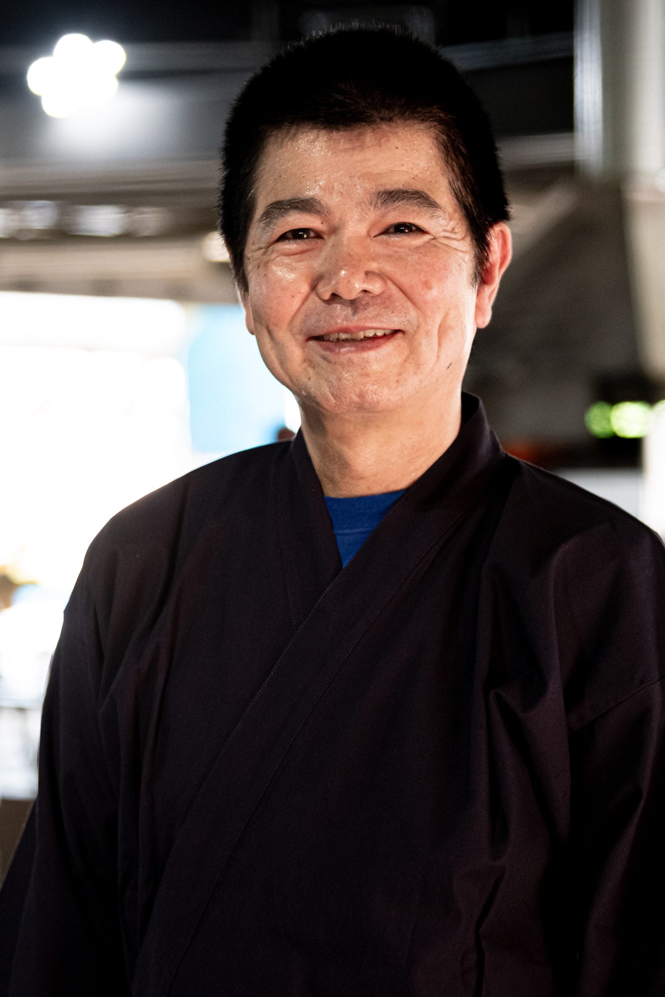 黒い作務衣を着て微笑む末吉清一